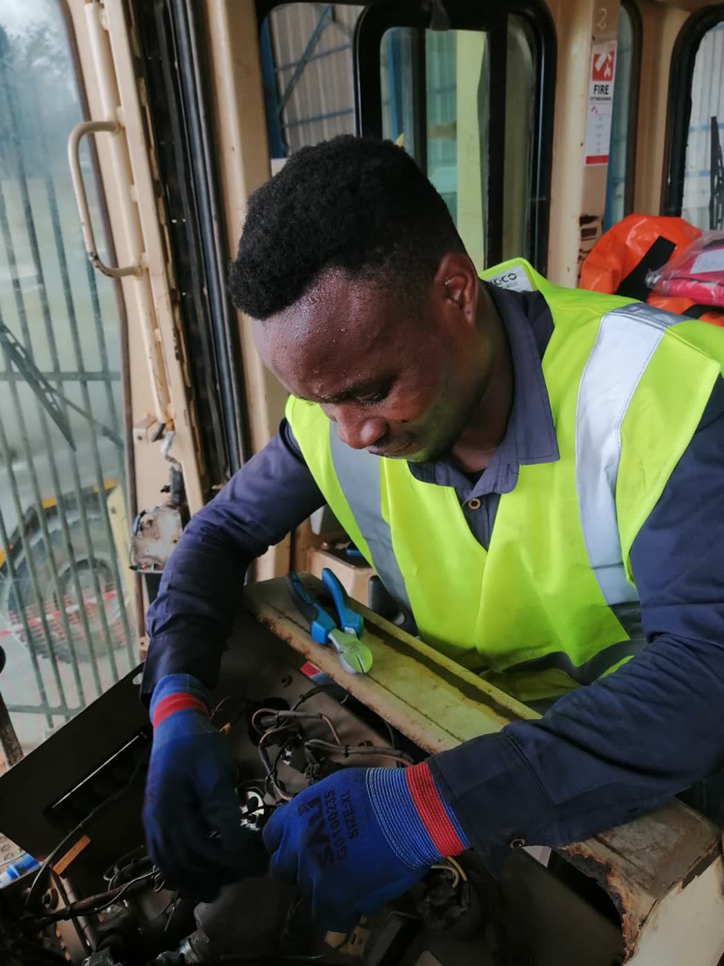Técnico a instalar equipamento na cabine de uma máquina